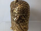 an image of a gold owl figurine sitting on a clear surface