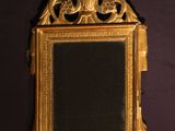 a gold mirror hanging on the wall with a black background