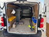 à l'arrière d'une camionnette dont la porte est ouverte et où se trouvent plusieurs cartons