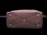 the pink purse is sitting on a black surface