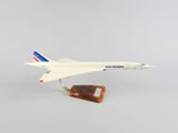 une maquette d'avion posée sur un socle en bois, sur fond blanc