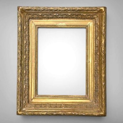 a gold framed mirror on a wall with a white background