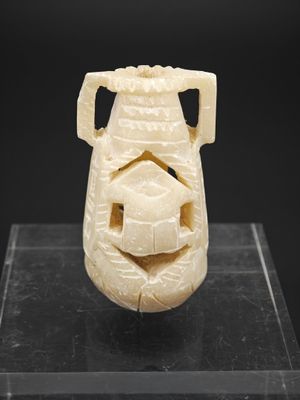 une image représentant un vase sculpté sur un fond noir