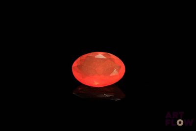 a red diamond on a black surface with a black background