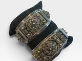 deux bracelets manchette noirs et argentés sur fond blanc