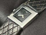 a black watch with a silver face on a black leather strap