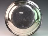 an antique silver plate with a silver rim on a gray background