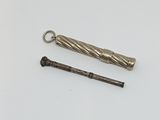 un petit objet métallique posé à côté d'un autre petit objet métallique