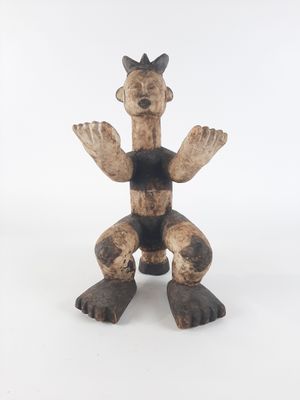 an image of a wooden statue of a man sitting on a white surface