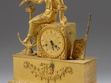 une horloge en or avec une femme assise dessus