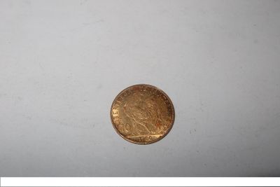 a gold coin sitting on top of a white surface