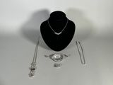 a necklace, bracelet, and ring on display on a table