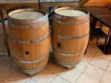deux tonneaux en bois posés l'un à côté de l'autre sur un sol carrelé
