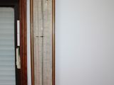 a tall thermometer on the wall in the corner of the room