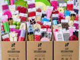 trois cartons contenant des articles différents, posés sur une palette