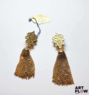 une paire de boucles d'oreilles en or ornées de pompons sur fond blanc