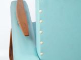 a blue chair that has a wooden arm rest on it