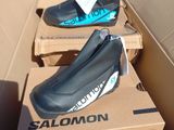 trois paires de chaussures posées sur une boîte en carton