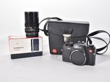 a black camera and a black bag on a white table