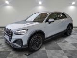 une Audi QX blanche de 2021 garée sur un sol à damier