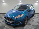 une ford fiesta bleue garée sur un sol en damier dans un garage