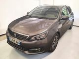 La voiture grise est garée dans une grande pièce au sol blanc.