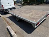 a flat bed trailer parked in a parking lot