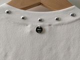 a close up of a white shirt hanging on a wooden hanger