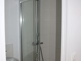 a shower with a glass door in a small bathroom