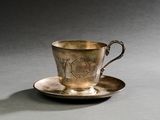 une tasse et une soucoupe en argent posées sur une table