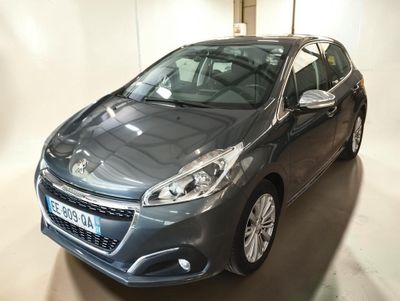 La voiture grise est garée dans le garage, la porte ouverte.