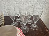 six wine glasses sitting on a table next to a bowl