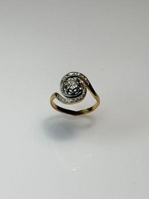 a close up of a gold ring with a diamond in the center