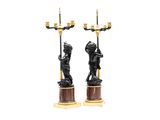 pair of black and gold candlesticks with a statue of a boy holding a candelabra