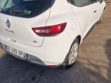 the rear end of a white car parked in front of a garage
