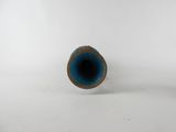 a small blue vase sitting on a white surface