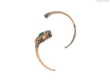 une image représentant une bague en or avec une pierre verte au centre