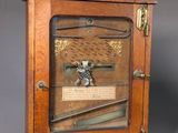 an old wooden clock with a glass case on the front of it