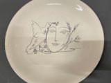 a white plate with a drawing of a bird on it
