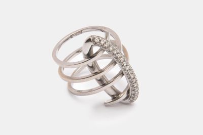 gros plan d'une bague sur une surface blanche avec des diamants