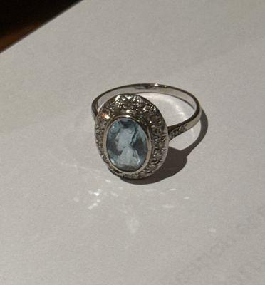 a close up of a ring with a blue topaz stone on it