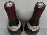 pair of two bottles of wine sitting on top of a white table