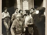 photographie en noir et blanc d'un groupe de personnes debout devant un bâtiment