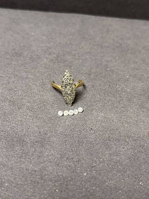 un gros plan d'une bague en or sertie de diamants sur une surface grise