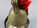 a gold helmet with a red pom pom on top of it