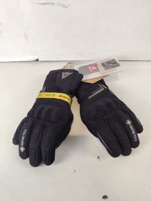 une paire de gants noirs posée sur une surface blanche, avec une étiquette