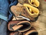 many pairs of shoes and jeans laid out on the floor