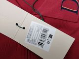 red polo shirt with a tag attached to it on a hanger