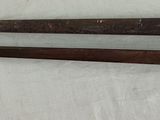 two old swords hanging on a wall next to each other