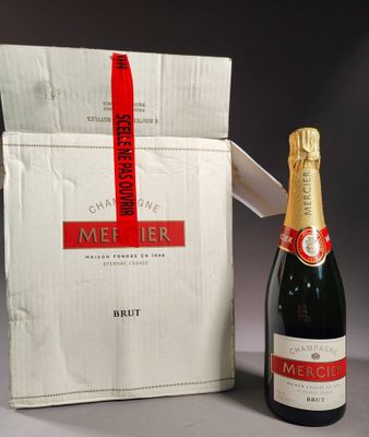 a bottle of champagne next to a box with a red ribbon